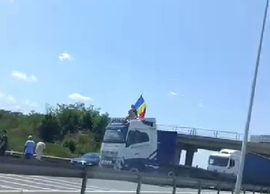 UPDATE - Sensul către Bucureşti al A1, blocat – Un şofer a oprit vehiculul de mare tonaj de-a latul şoselei şi s-a urcat pe cabină, fluturând steagul României / Trafic deviat - VIDEO