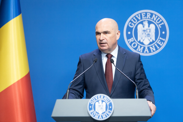 Premierul Ilie Bolojan prezintă astăzi pachetul de măsuri fiscale pentru „corectarea deficitul bugetar”: Cota generală de TVA crește la 21%